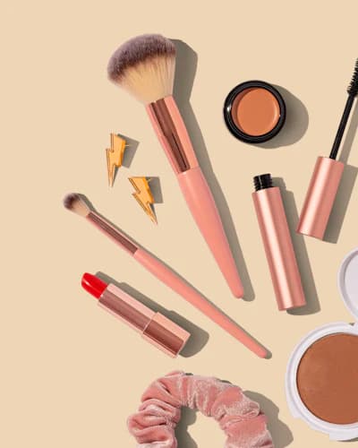 Pincéis e cosméticos organizados sobre fundo bege