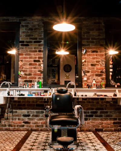 Cadeira de barbearia em salão de parede de tijolos
