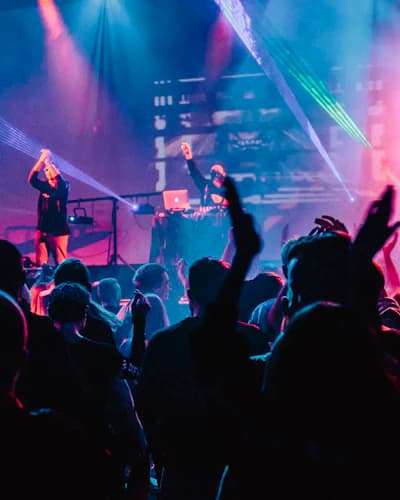 Plateia com as mãos erguidas em um show iluminado